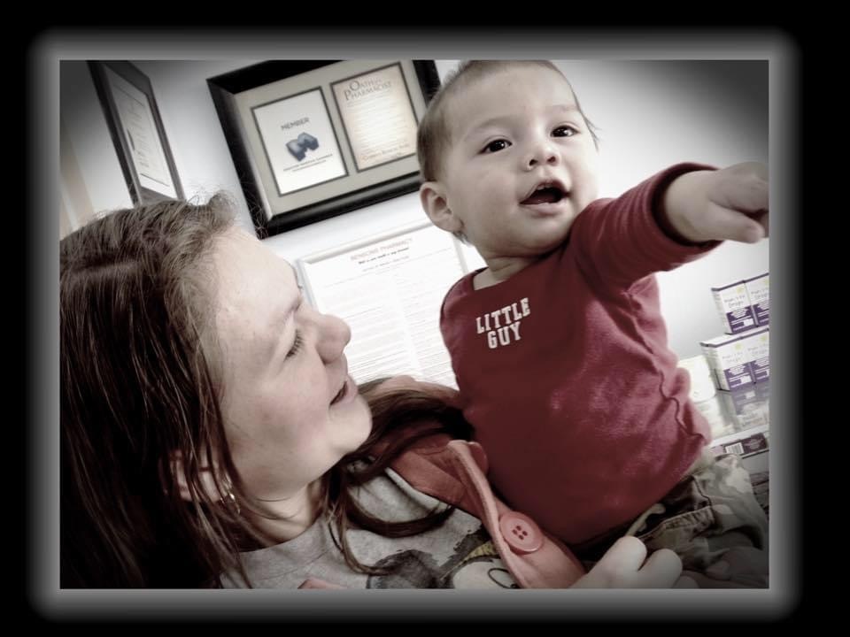 An adult holds a baby in a framed photograph