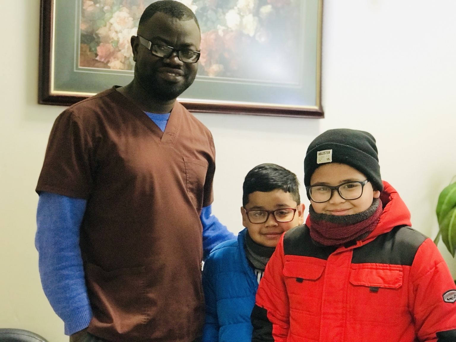Una persona adulta posa junto a dos niños