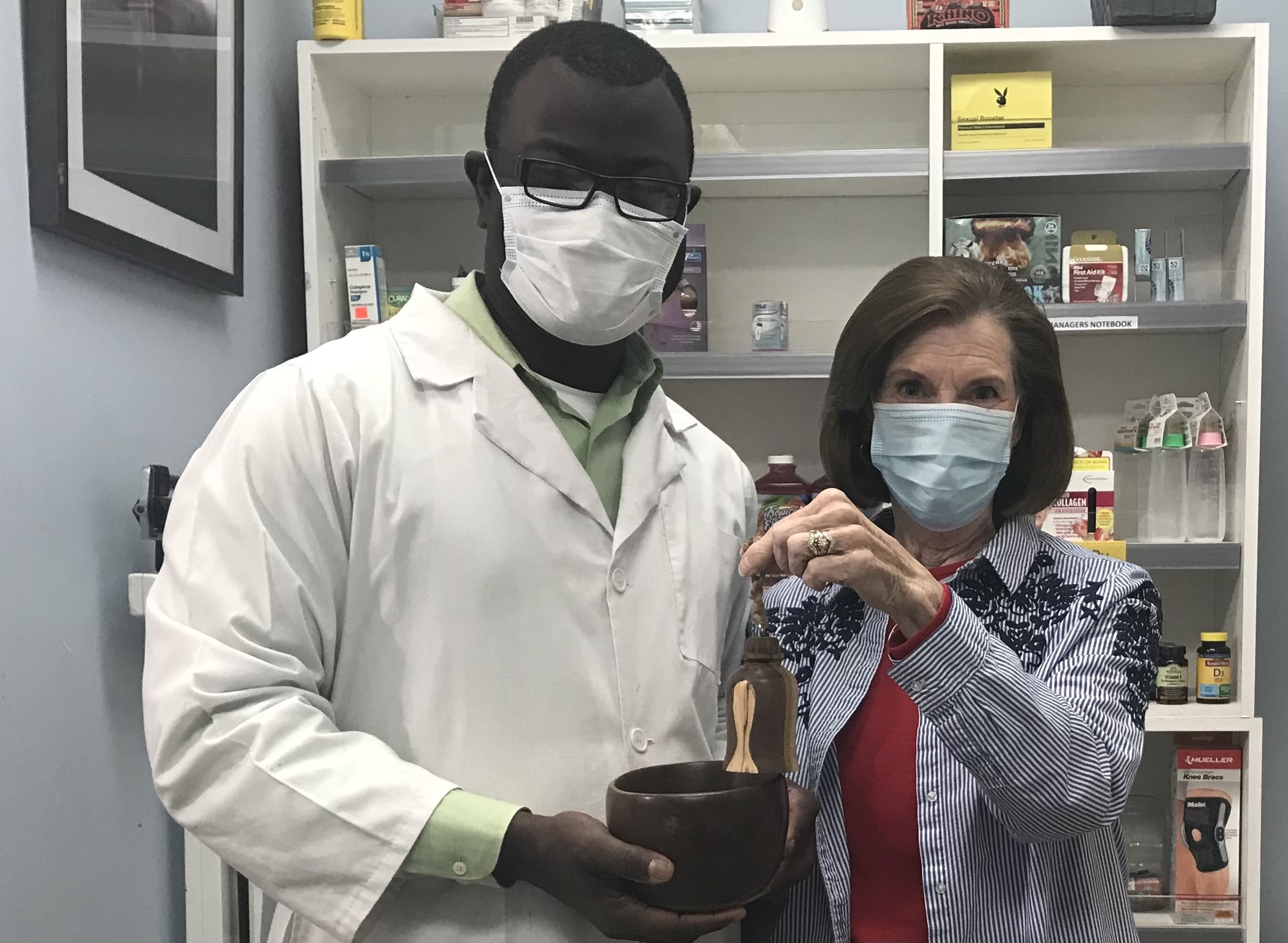 Dos personas posan con mascarillas en la farmacia