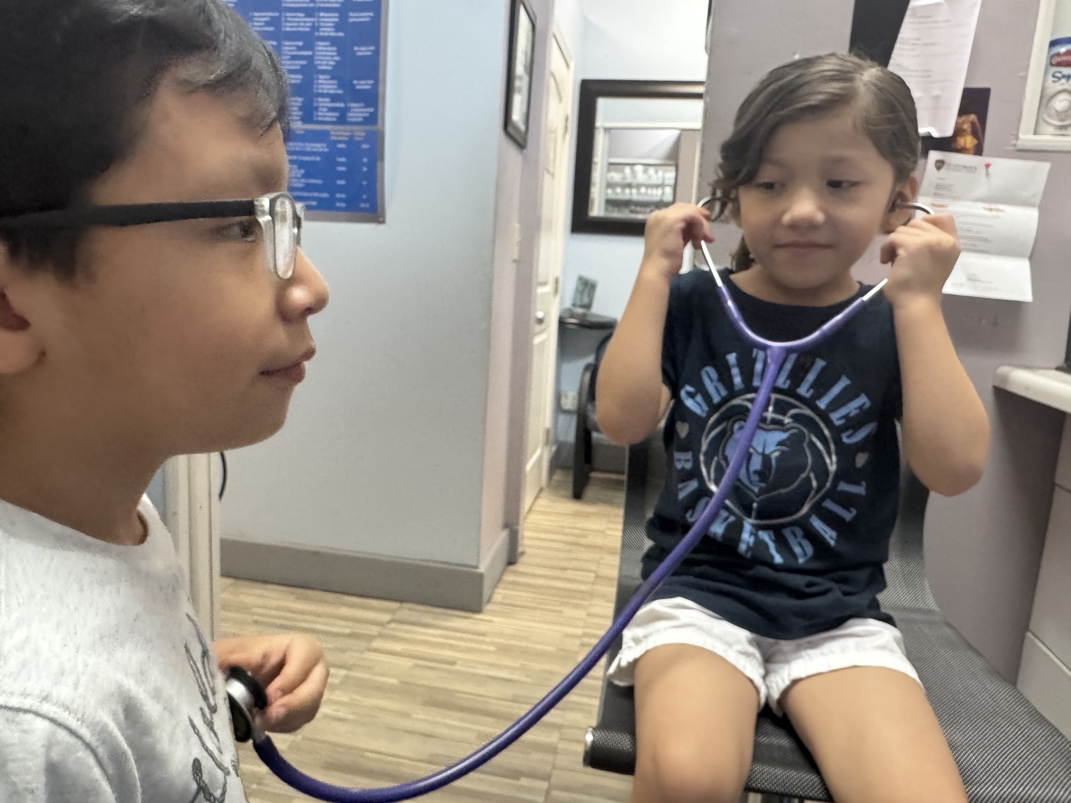 Dos niños juegan con un estetoscopio